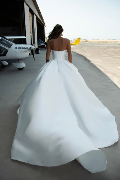 Strapless Mikado wedding dress with sculpted corset bodice, structured waist, and full flowing skirt in luminous white fabric for modern bridal look
