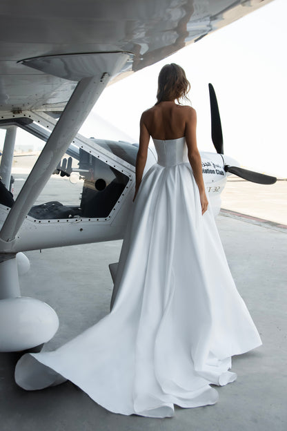 Strapless Mikado wedding dress with sculpted corset bodice, structured waist, and full flowing skirt in luminous white fabric for modern bridal look