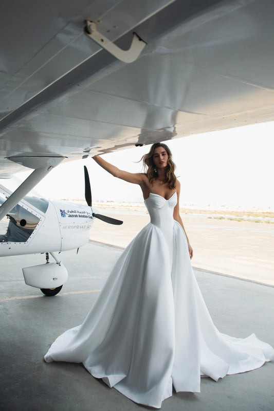 Strapless Mikado wedding dress with sculpted corset bodice, structured waist, and full flowing skirt in luminous white fabric for modern bridal look