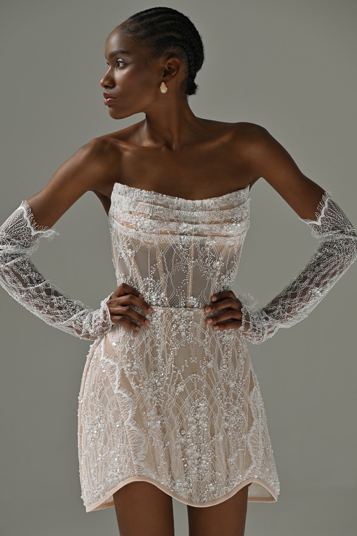 Strapless lace mini wedding dress – close-up of the beaded lace bodice and long lace gloves, hands on hips