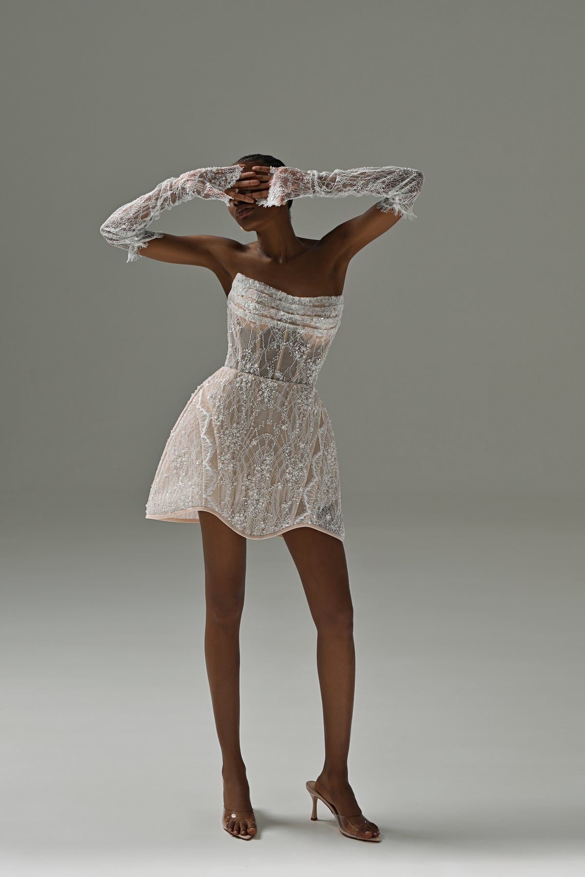 Strapless lace mini wedding dress with flared skirt – full-length front view with arms overhead