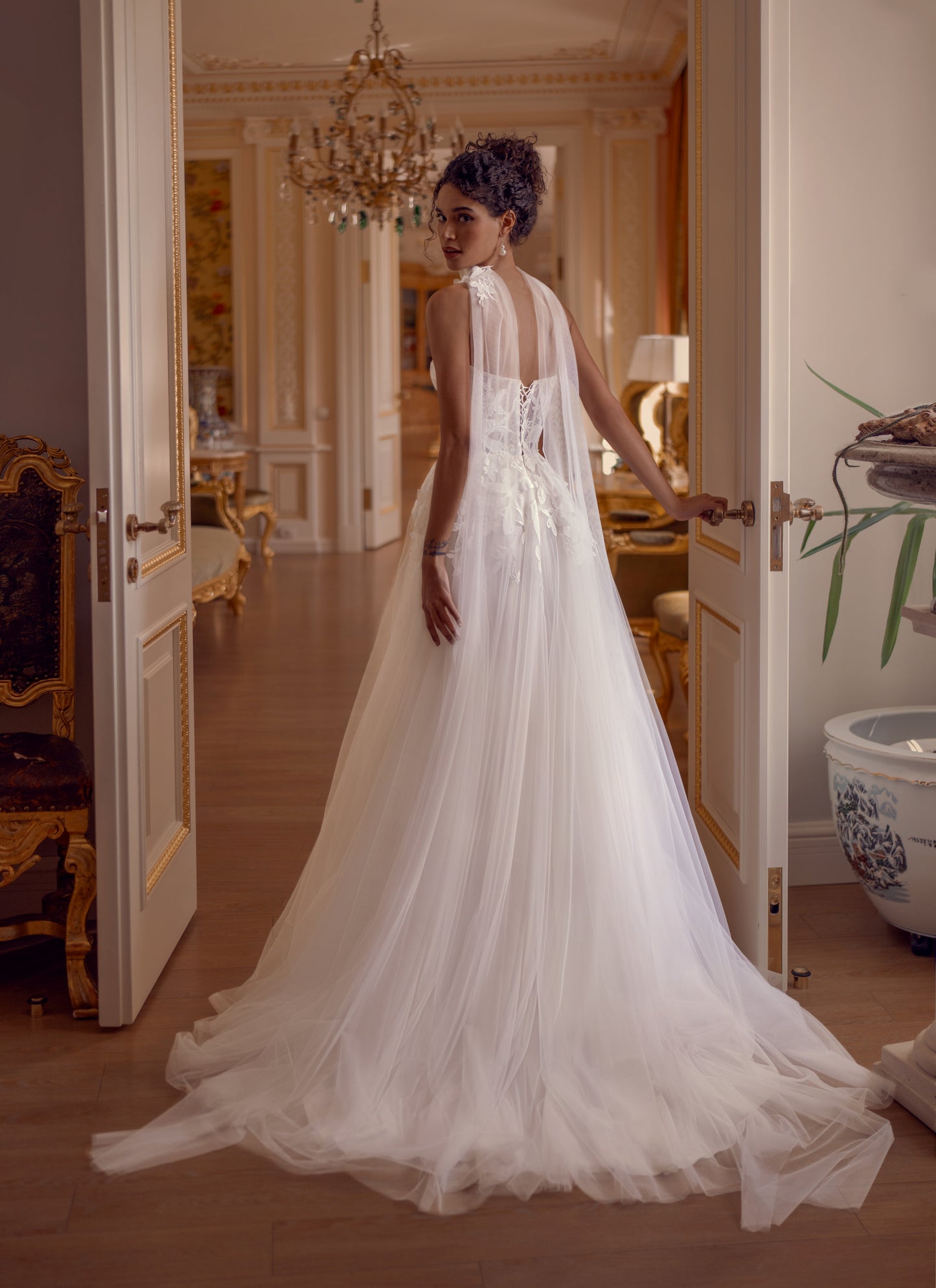 Bride wearing a floral appliqué A-line wedding dress with sweetheart corset and flowing tulle skirt.
