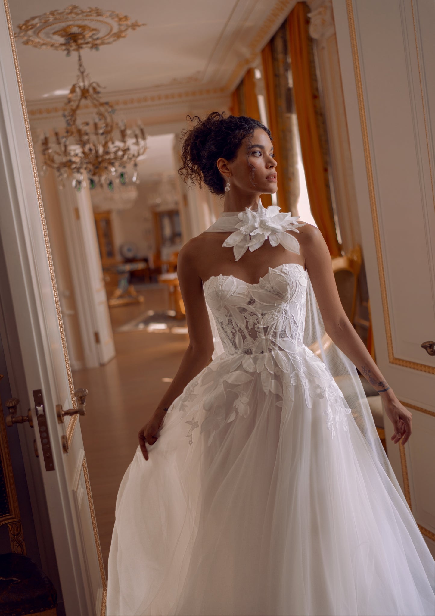 Bride wearing a floral appliqué A-line wedding dress with sweetheart corset and flowing tulle skirt.
