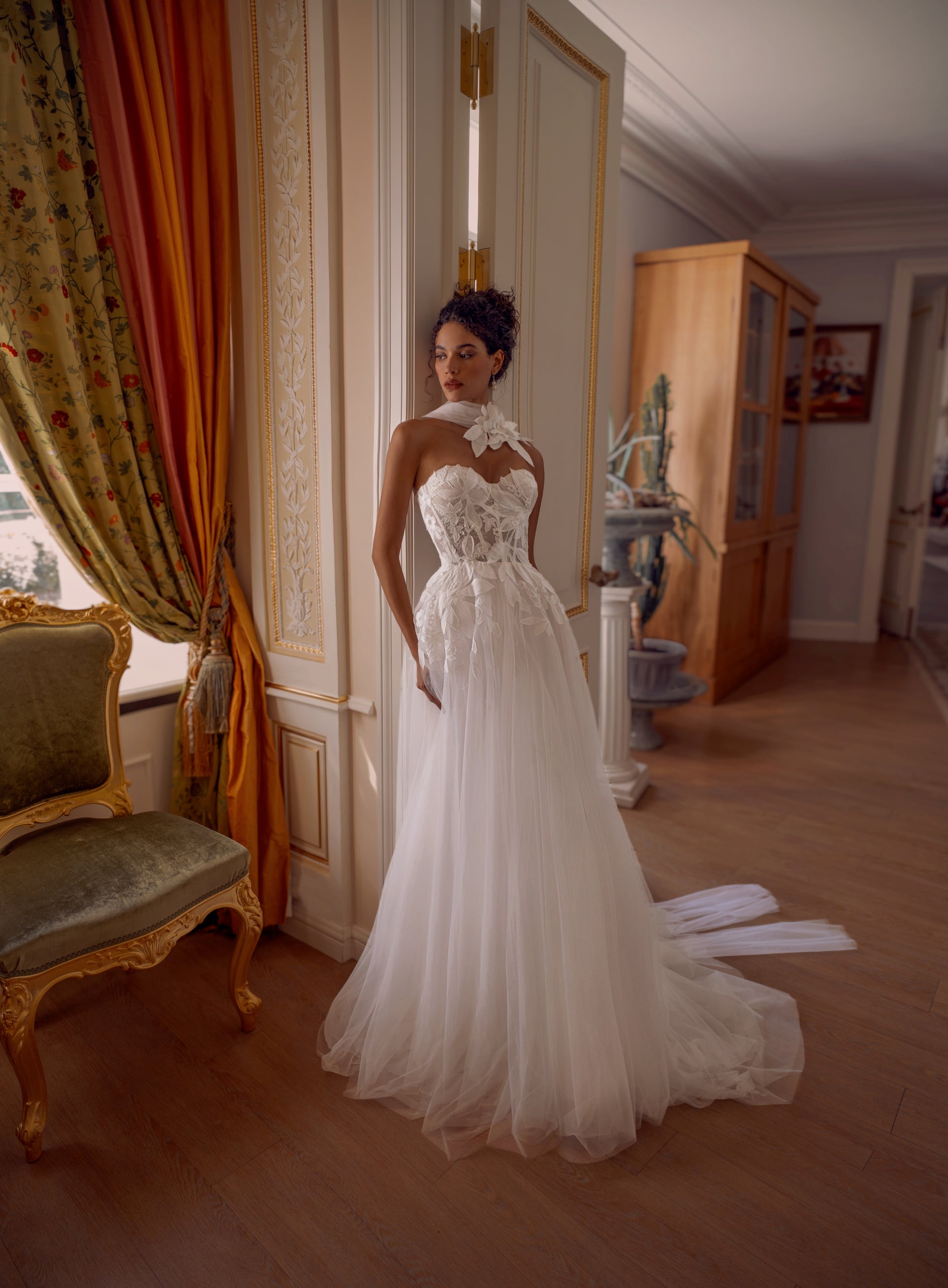 Bride wearing a floral appliqué A-line wedding dress with sweetheart corset and flowing tulle skirt.