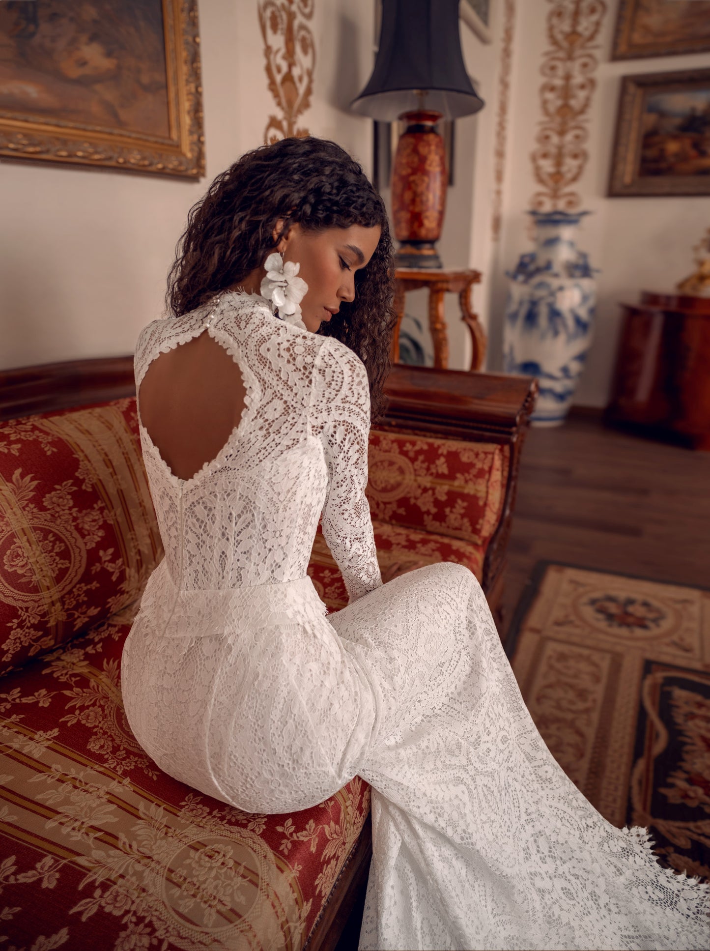 Long-sleeve high-neck lace mermaid wedding gown with open back and scalloped train.