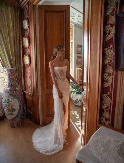 Bride wearing sculpted lace mermaid wedding gown with corset and optional bolero.
