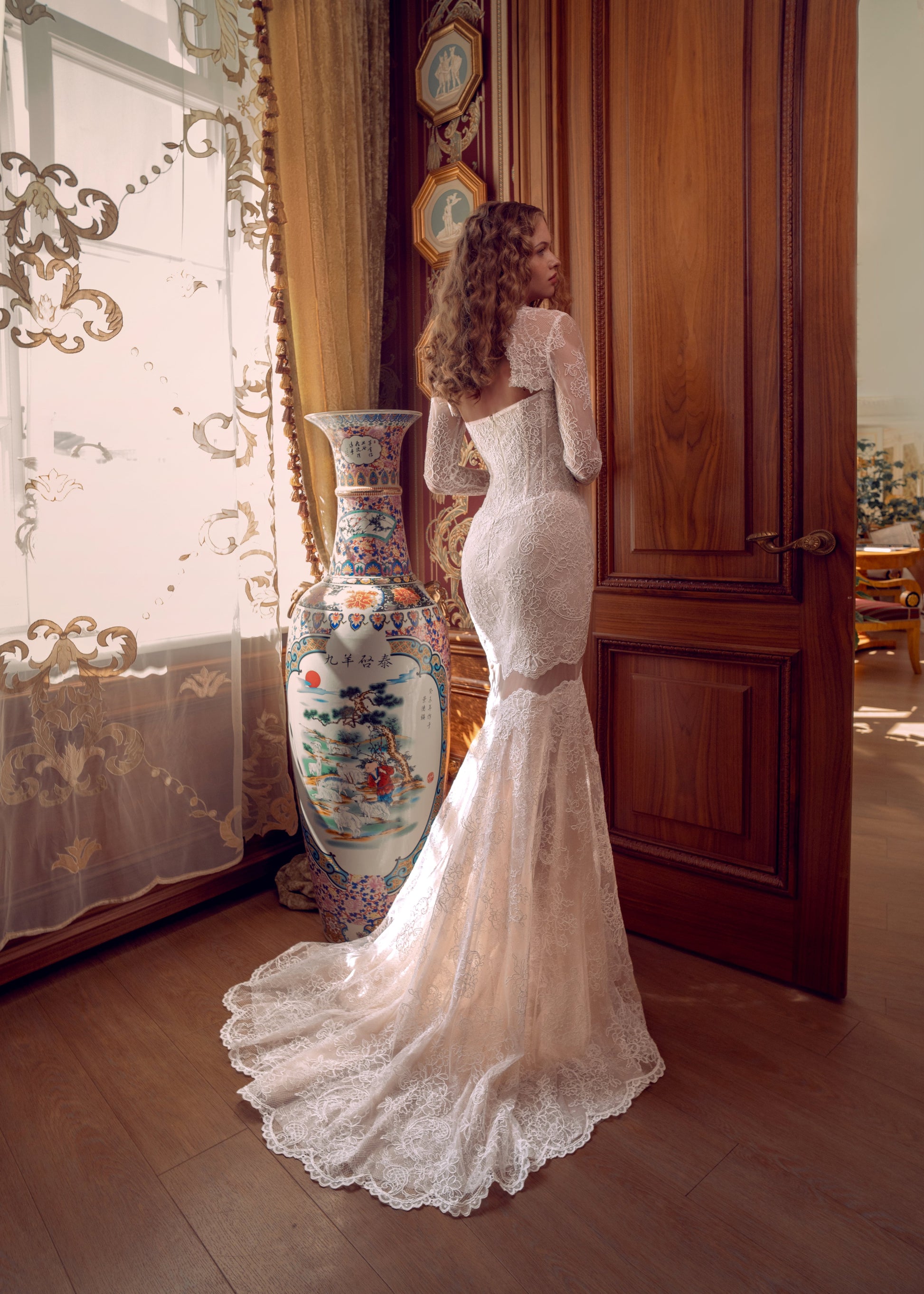 Bride wearing lace mermaid wedding gown with removable long-sleeve bolero