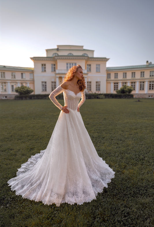Romantic off-shoulder lace A-line wedding gown with long sleeves and corset bodice.