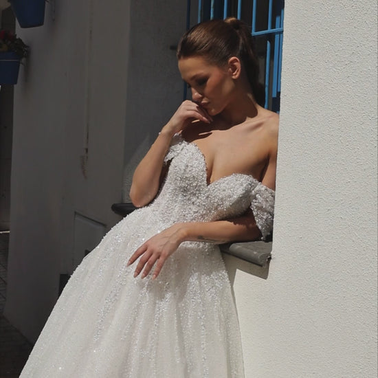 Sleeveless A-line lace bridal gown with sweetheart neckline, pearl straps, pearl and sequin embroidery, and glittering tulle skirt.