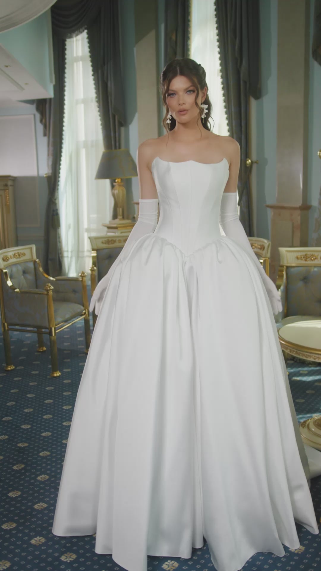 Mikado A-line wedding dress with reverse sweetheart neckline, drop-down waspie corset, sleeveless design, long gloves, zip closure, and flowing chapel train for elegant modern bridal look