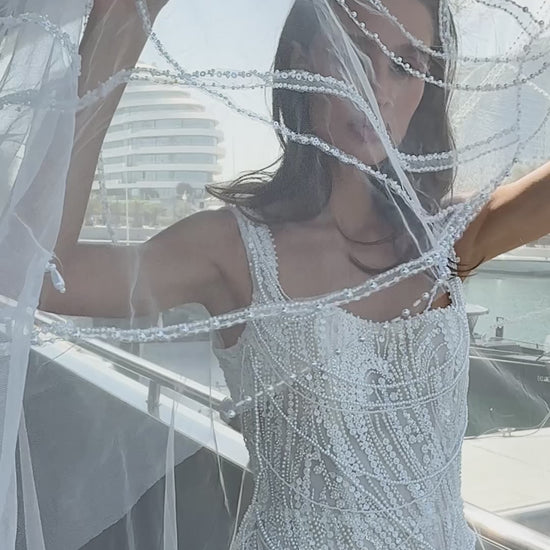 Sculpted beaded mermaid wedding gown with scoop neckline, pearl-inspired detailing, and soft tulle chapel train.