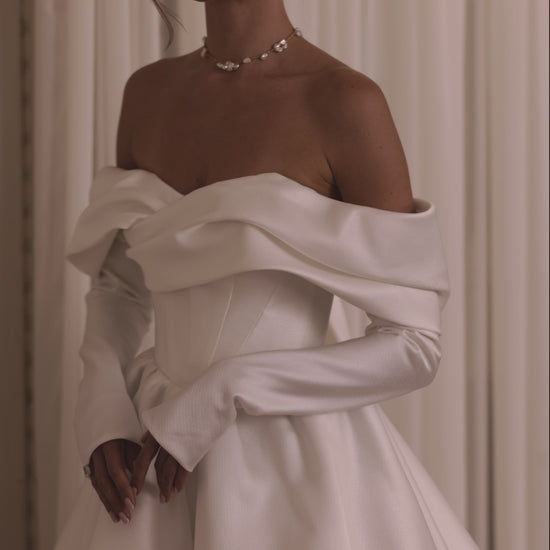 Bride wearing a two-in-one mini wedding dress with detachable mikado train and sculpted off-shoulder bodice.

