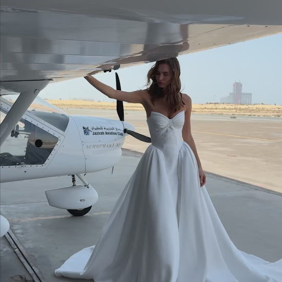 Strapless Mikado wedding dress with sculpted corset bodice, structured waist, and full flowing skirt in luminous white fabric for modern bridal look