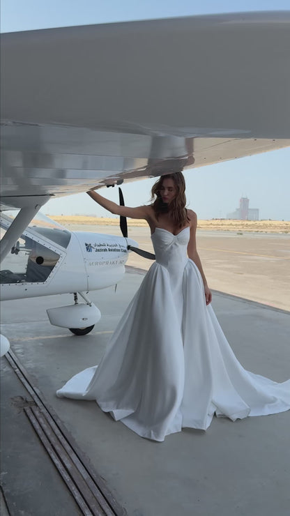 Strapless Mikado wedding dress with sculpted corset bodice, structured waist, and full flowing skirt in luminous white fabric for modern bridal look