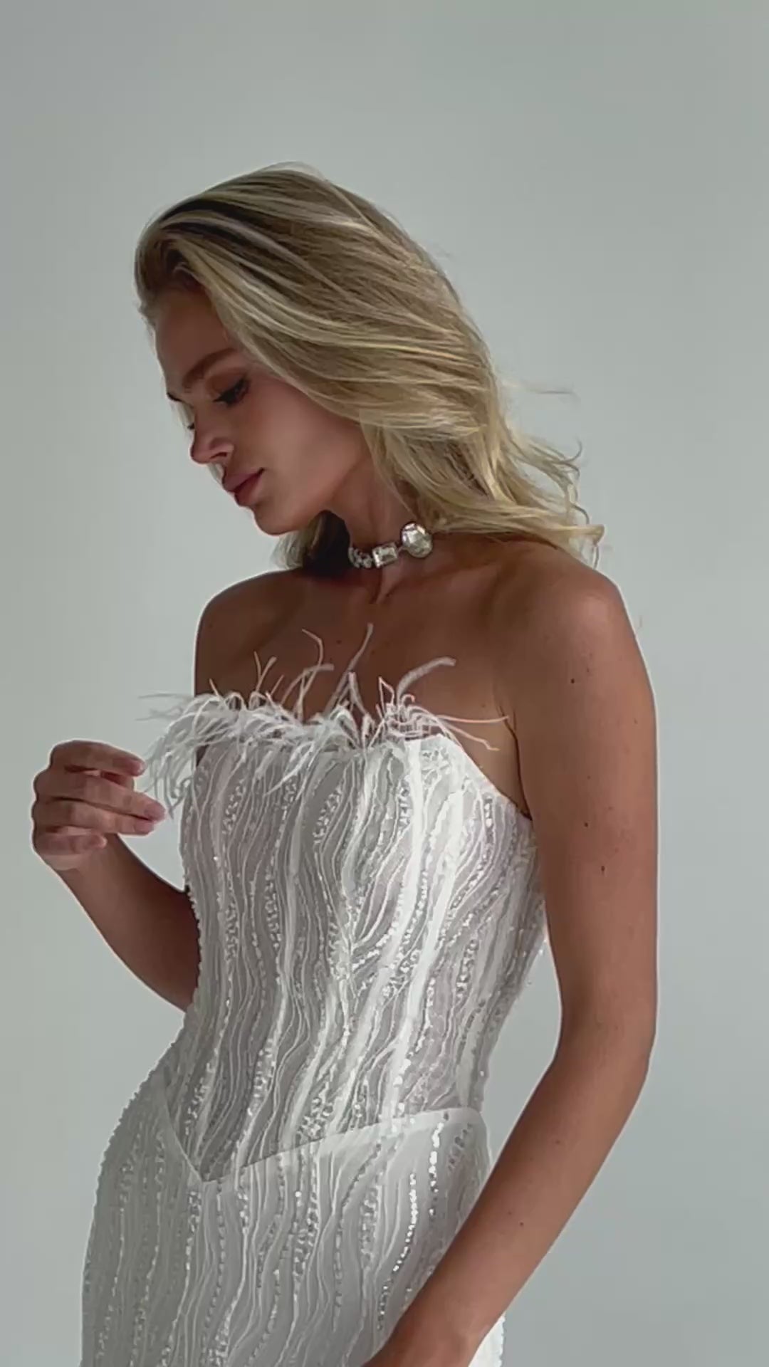 Video: feather-trimmed corset bodice with a pearl choker, looking down