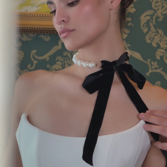 Video of a strapless fit-and-flare wedding dress with a basque waist, sculpted pleated hip panels and flowing train.