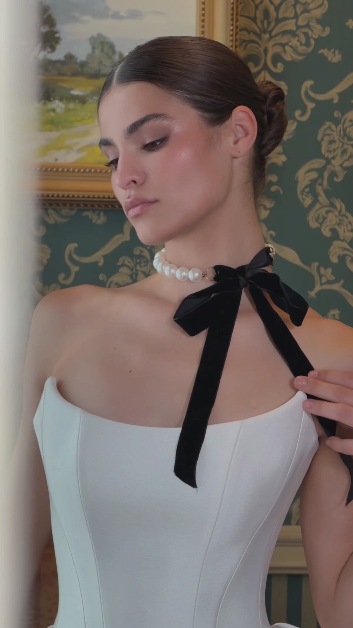 Video of a strapless fit-and-flare wedding dress with a basque waist, sculpted pleated hip panels and flowing train.