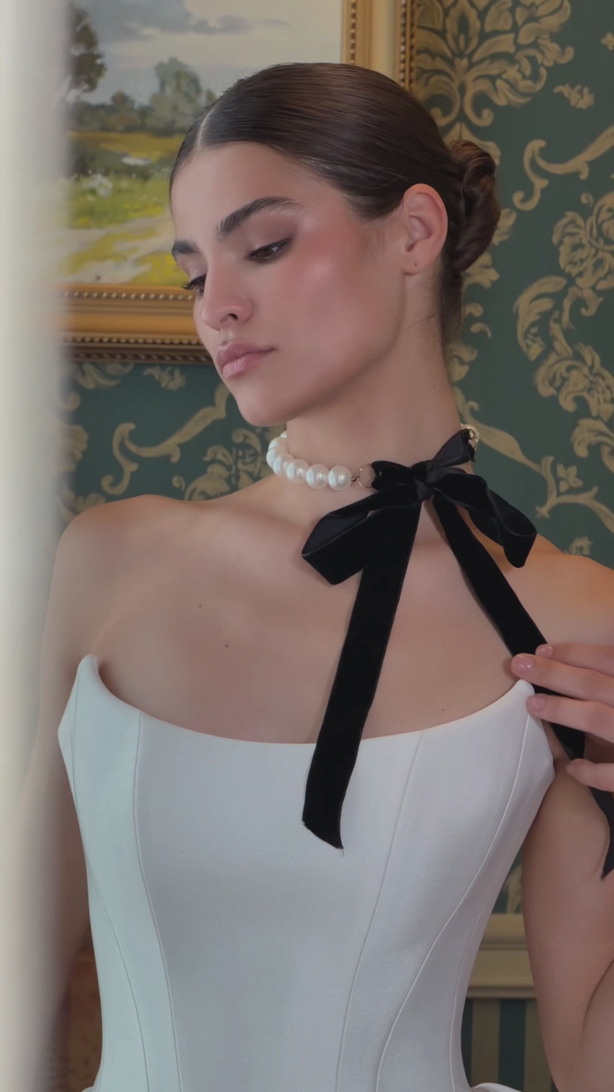 Video of a strapless fit-and-flare wedding dress with a basque waist, sculpted pleated hip panels and flowing train.