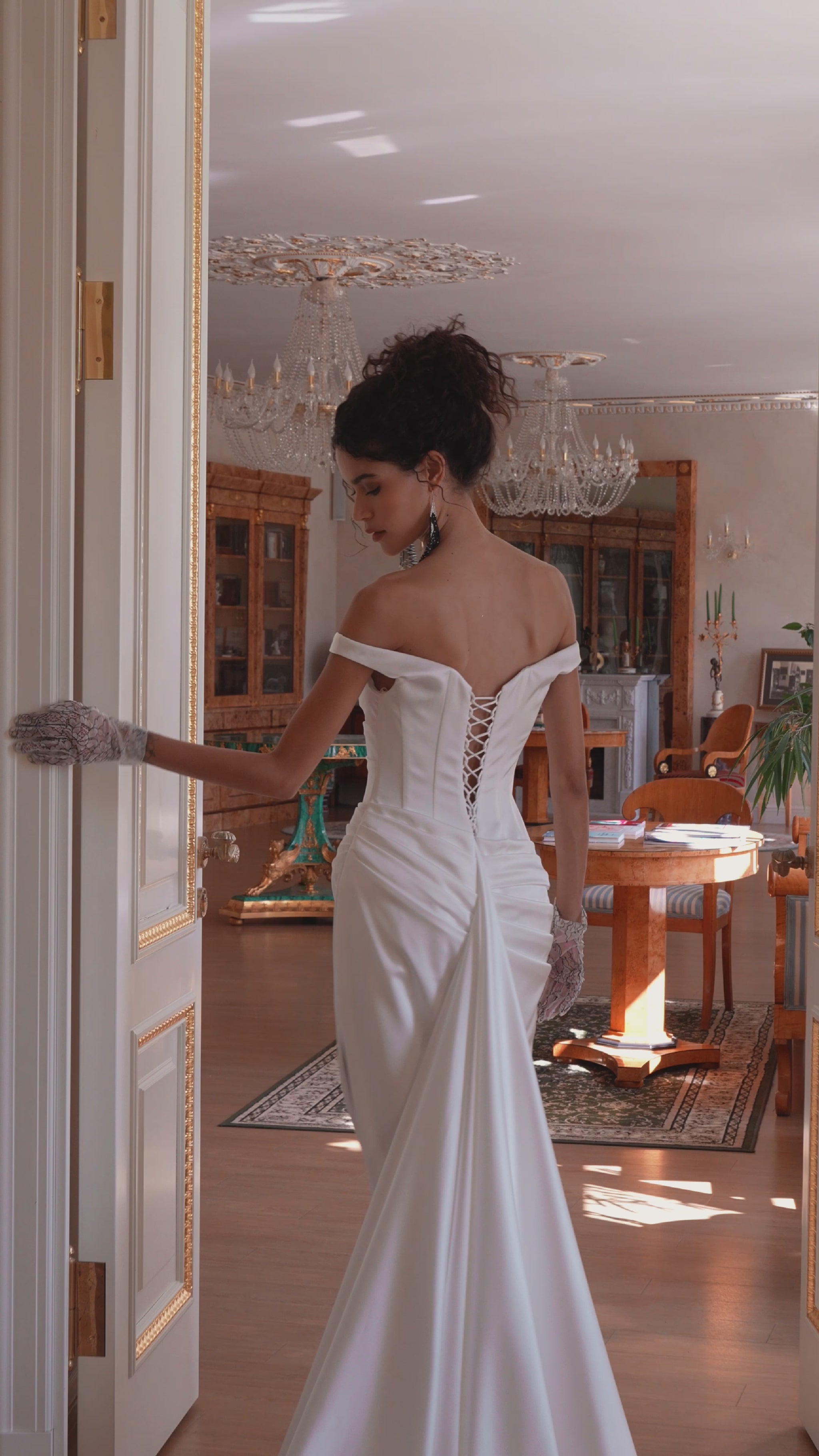 Bride in off-shoulder satin mermaid wedding gown with draped bodice, thigh-high slit, lace-up back, and sweep train.