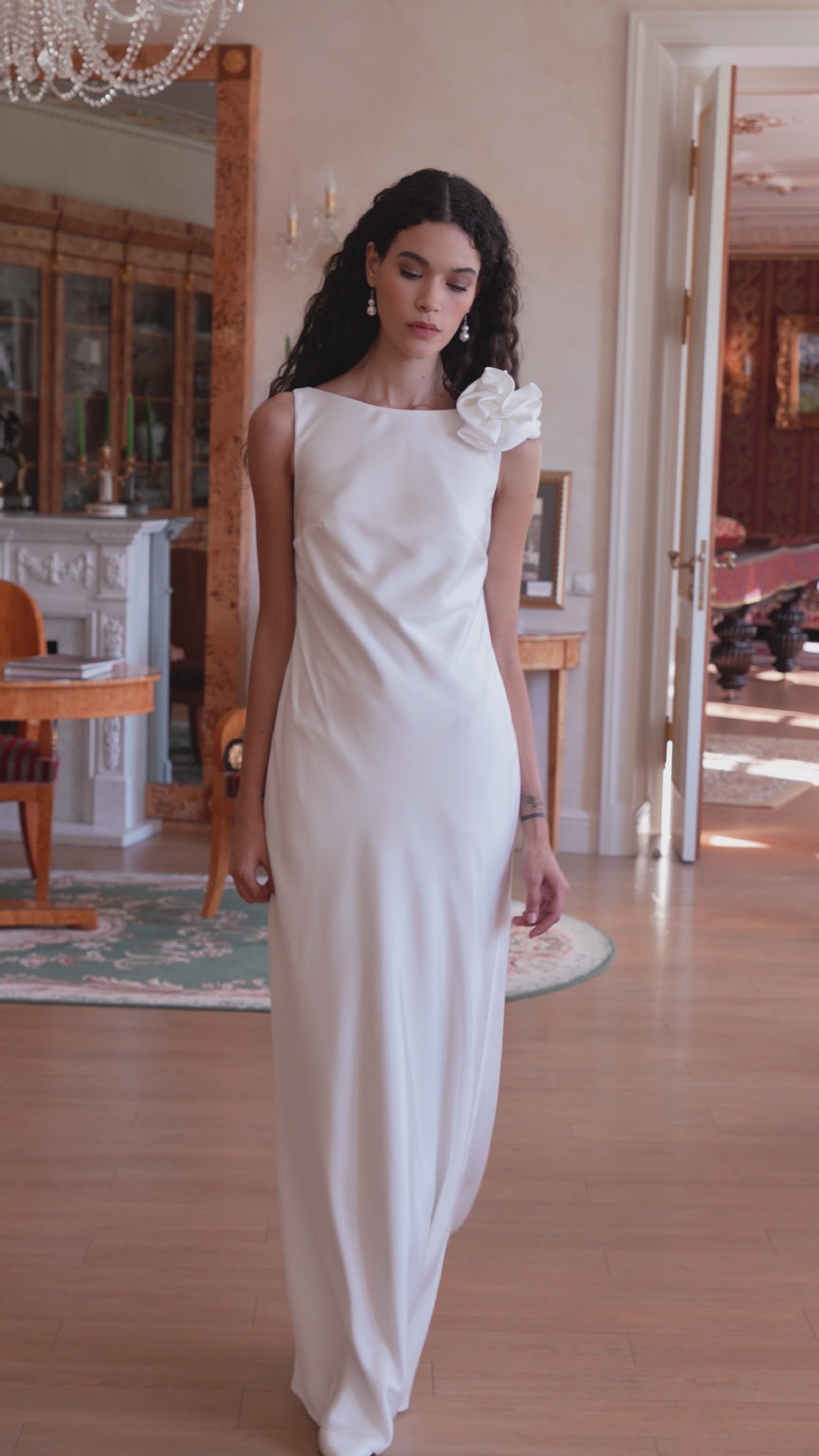 Minimalist silk wedding gown with sculpted rose shoulder and open back.