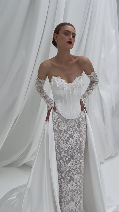 Fitted wedding dress with lace sleeves and corset back.