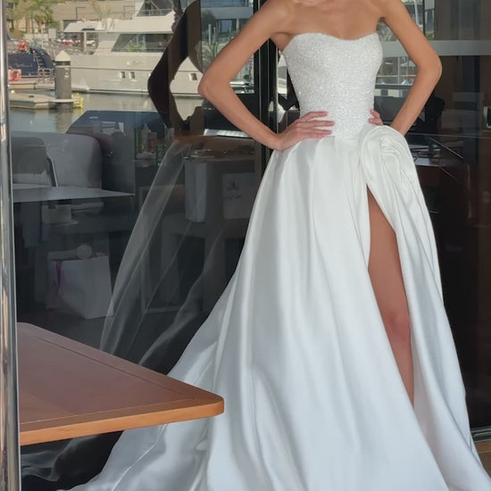 Mikado wedding gown with beaded lace corset, strapless neckline, and high slit.