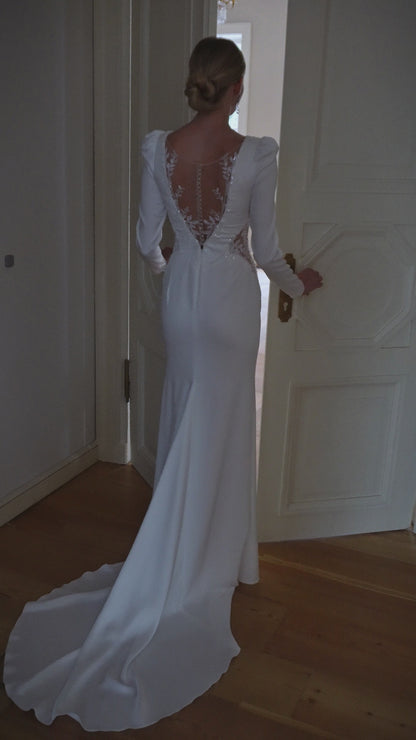 Satin long sleeve sheath wedding dress with deep-V neckline.
