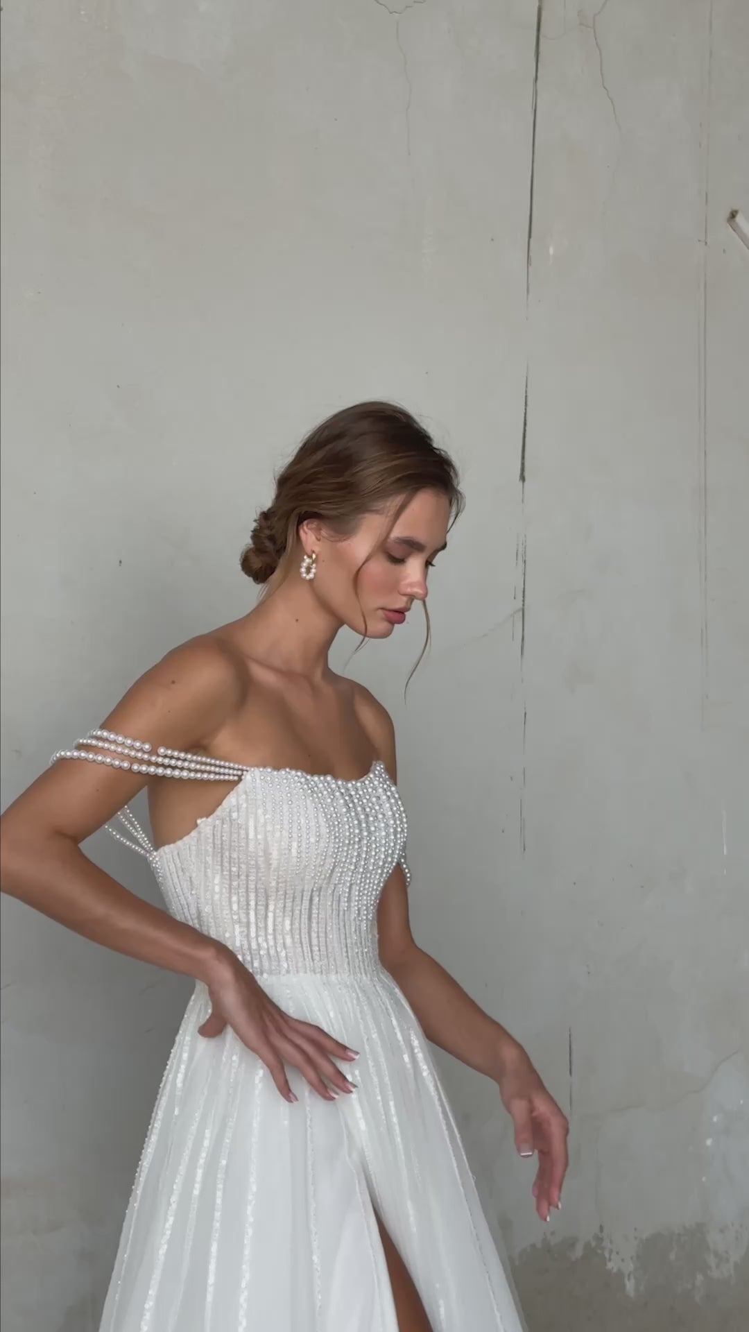 Pearl-embroidered tulle wedding dress with beaded corset bodice, detachable sheer sleeves, thigh-high slit, and flowing layered skirt