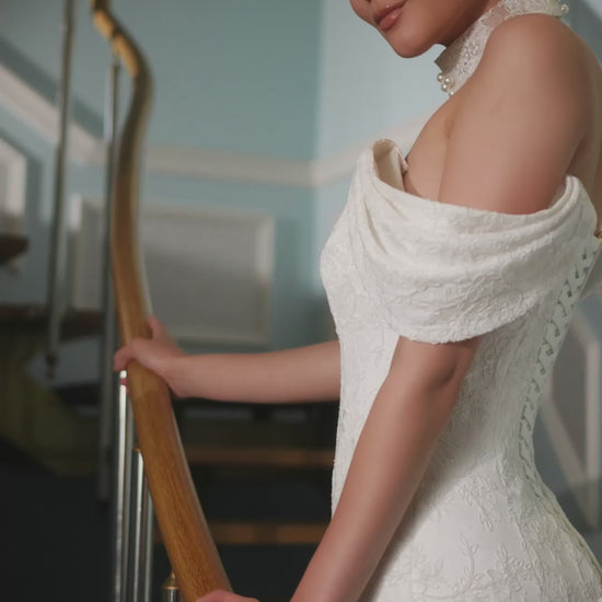 Full-length lace mermaid wedding dress with fit and flare silhouette, draped off-shoulder sleeves, V-neckline, removable lace and pearl choker, lace-up back closure, and elegant fishtail train for modern bridal look