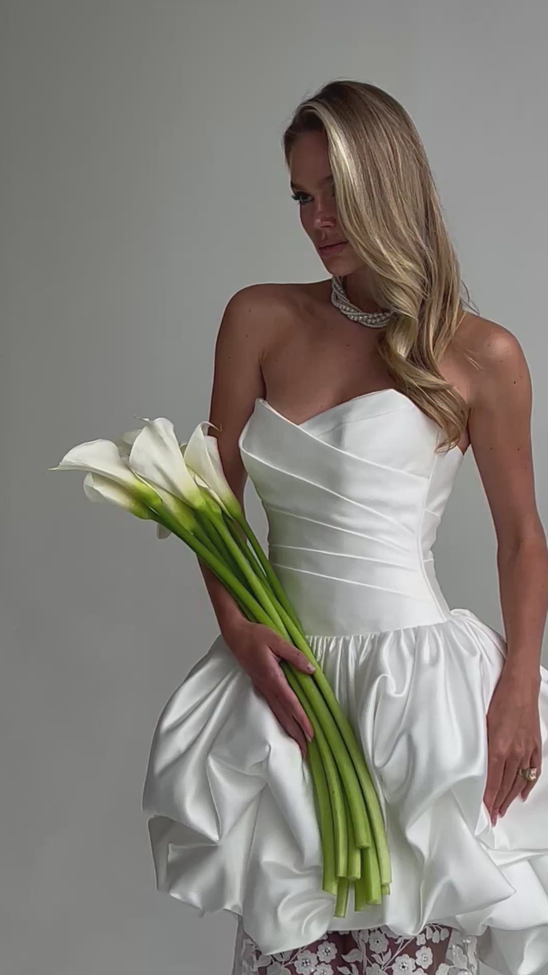 Video: close-up of a ruched satin sweetheart bodice with calla lilies