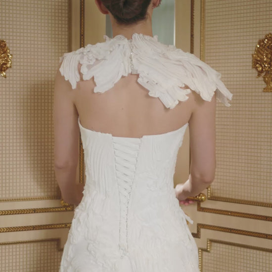 Explore this sculpted lace A-line wedding dress with removable bolero, strapless bodice option, and chapel train. A couture bridal gown offering elegance and versatility.