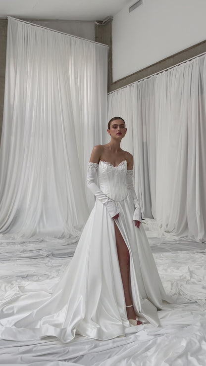 Elegant bridal gown featuring long removable sleeves and chapel train.