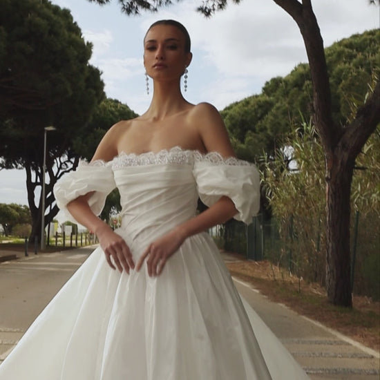 Princess taffeta bridal gown with detachable off-the-shoulder sleeves, draped bodice, straight lace neckline, open back, lace-up closure, and cathedral train.