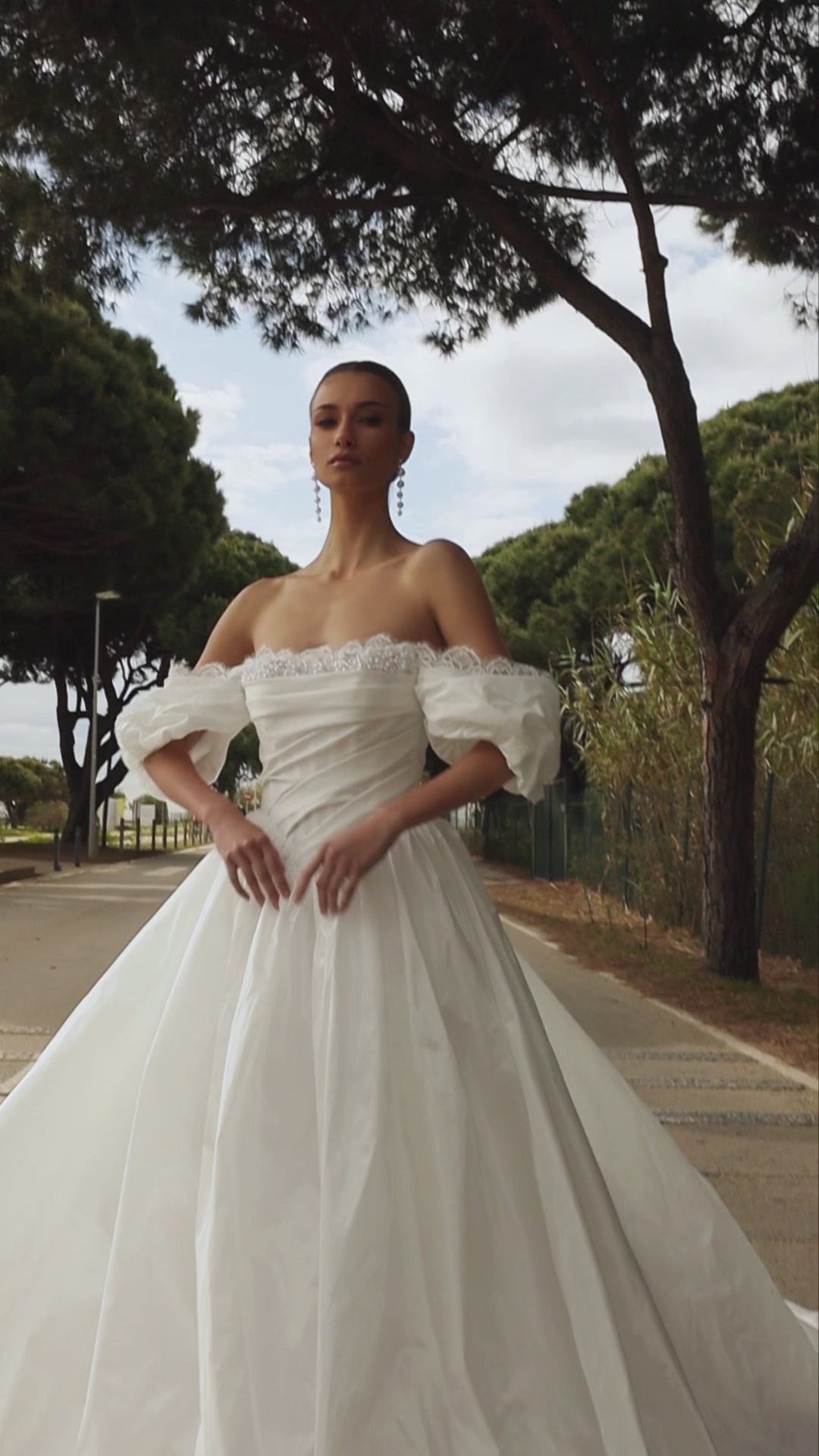Princess taffeta bridal gown with detachable off-the-shoulder sleeves, draped bodice, straight lace neckline, open back, lace-up closure, and cathedral train.