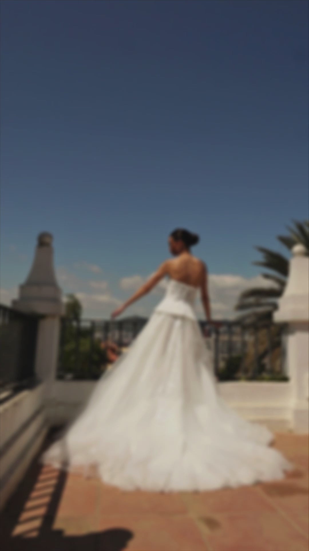 Bride in strapless sweetheart sleeveless A-line wedding gown with sequin lace corset, flowing tulle skirt, and chapel train.