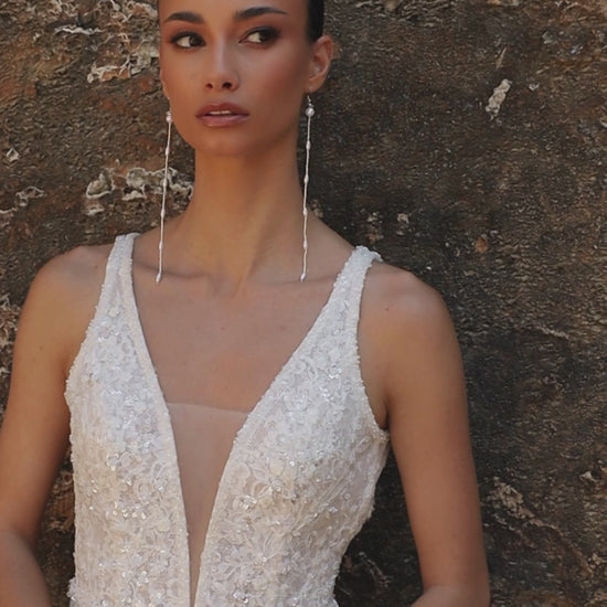 Bride in mermaid sequin embroidered lace wedding gown with deep-V neckline, open keyhole back, and sweep train.