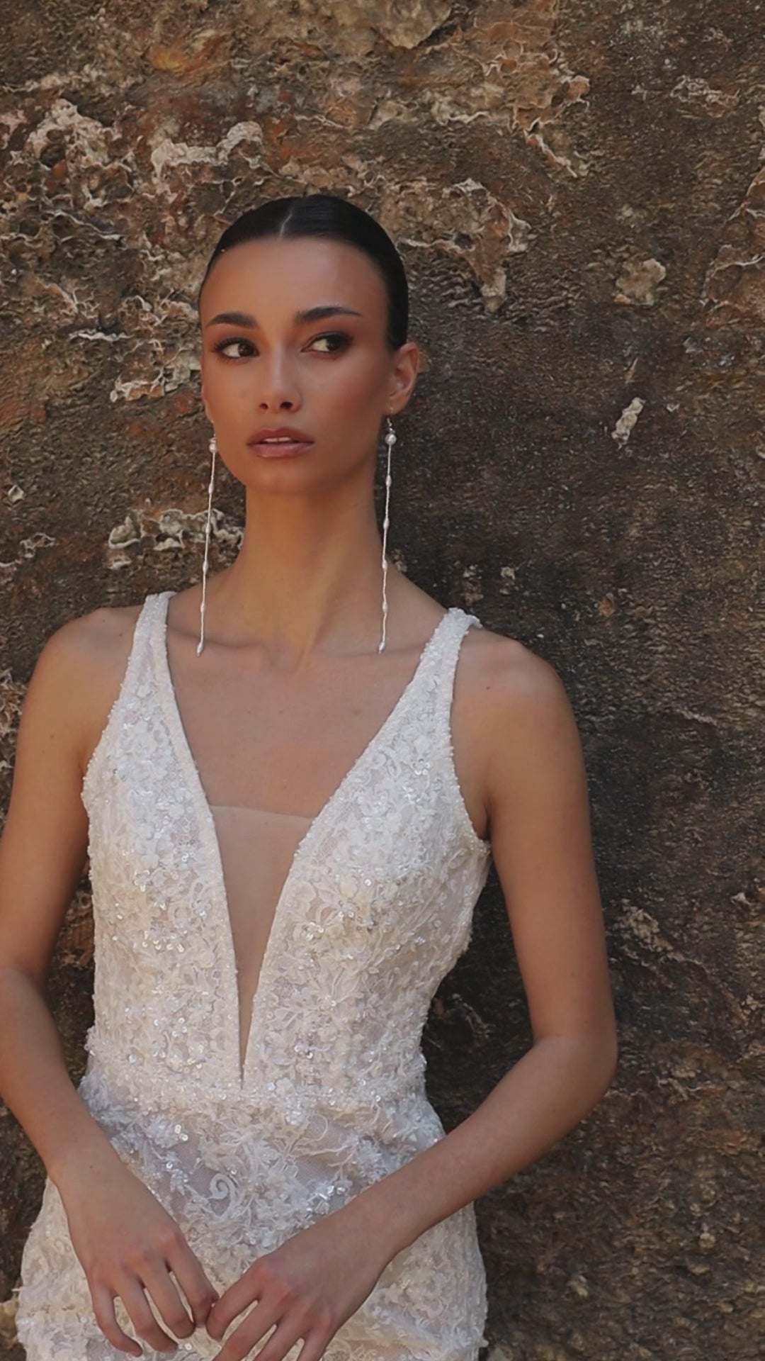 Bride in mermaid sequin embroidered lace wedding gown with deep-V neckline, open keyhole back, and sweep train.