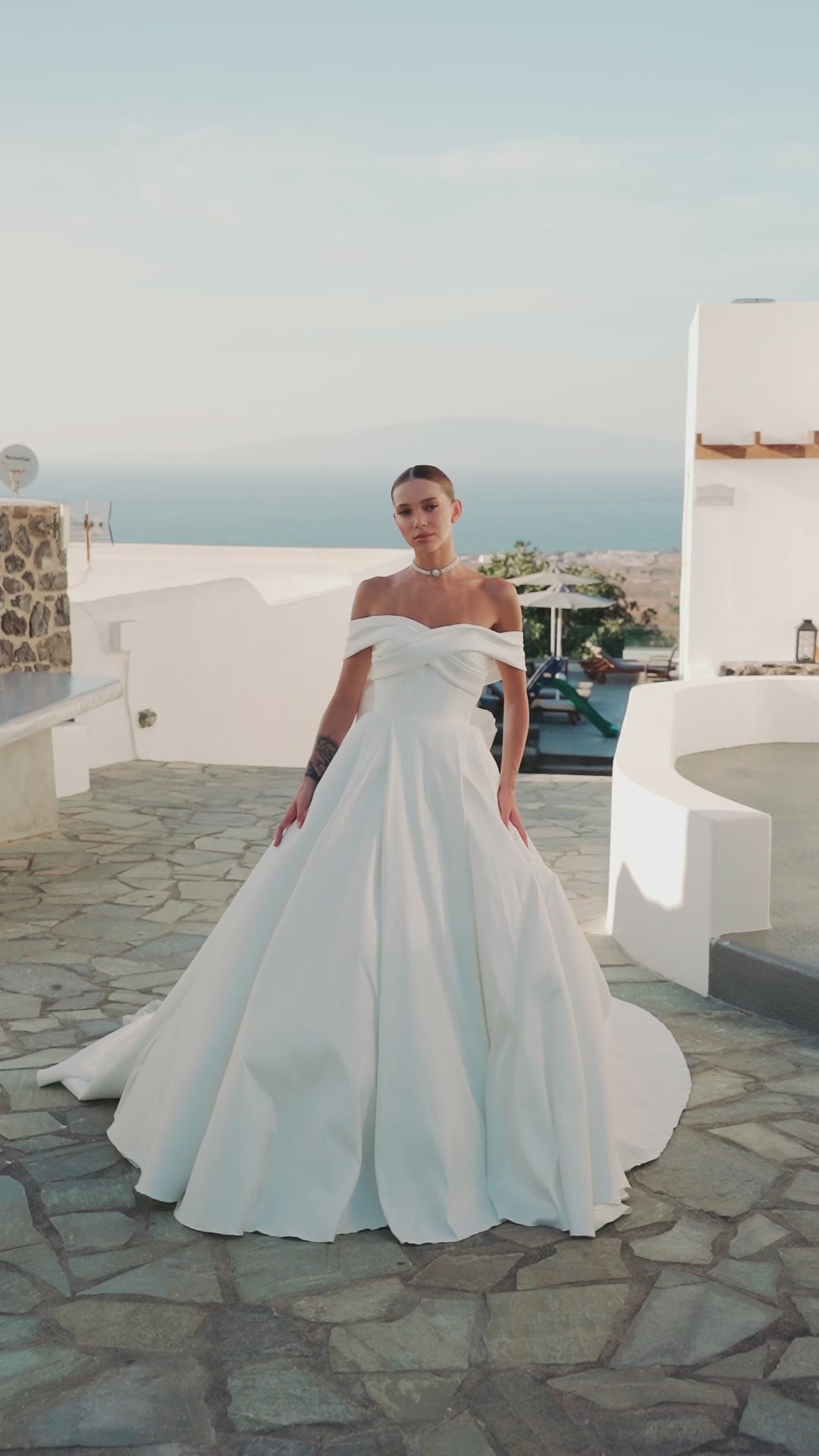 A-line wedding dress with off-the-shoulder neckline and bow.