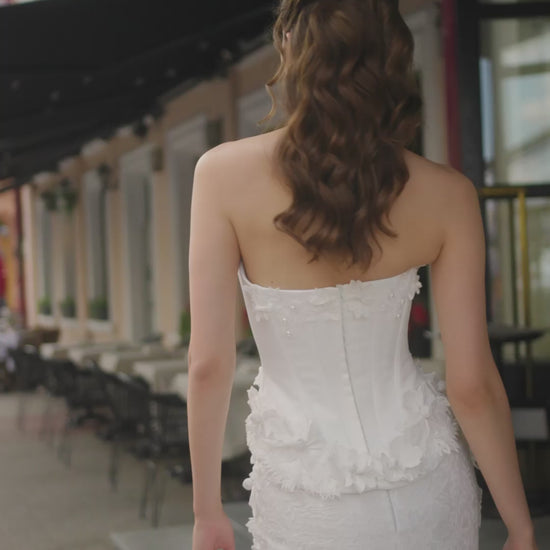 Bride wearing trumpet wedding dress with sleeveless Mikado corset, boat neckline, lace skirt, and sweep train.