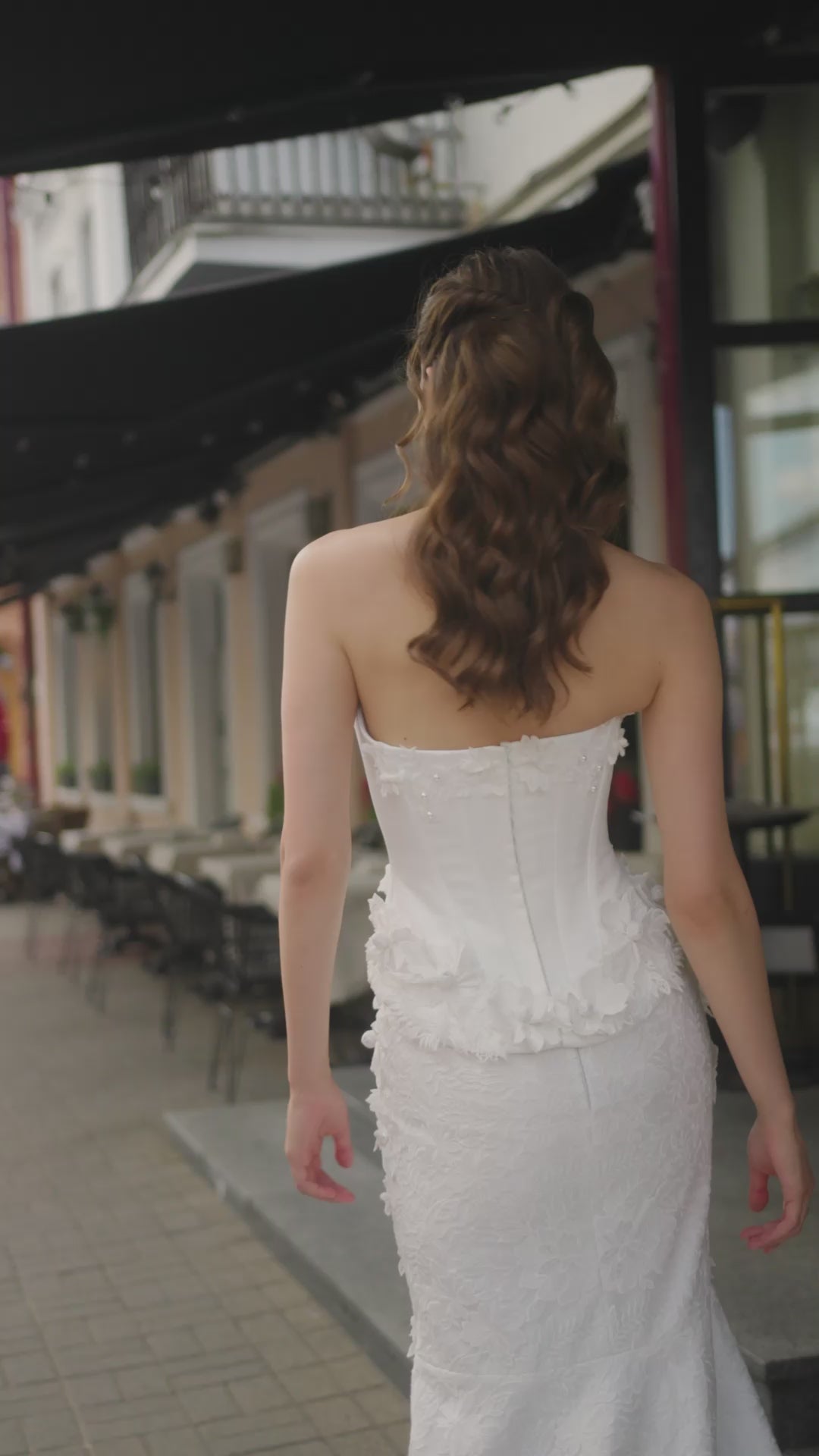 Bride wearing trumpet wedding dress with sleeveless Mikado corset, boat neckline, lace skirt, and sweep train.