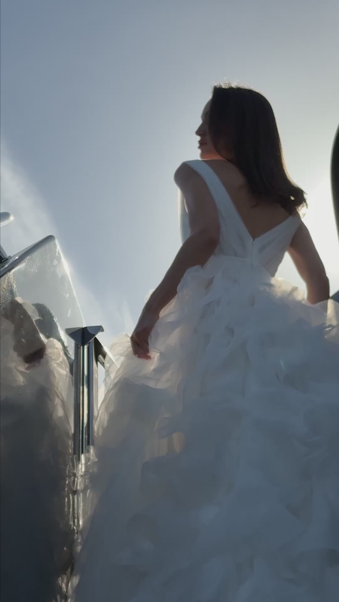 Ethereal tulle ball gown with deep V-neckline and layered airy skirt.