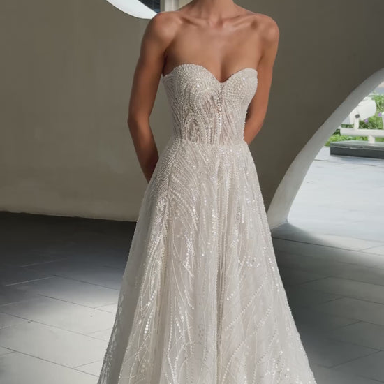 beaded A-line bridal gown with detachable illusion high-neck bolero, sheer long sleeves, button-back, and chapel train.