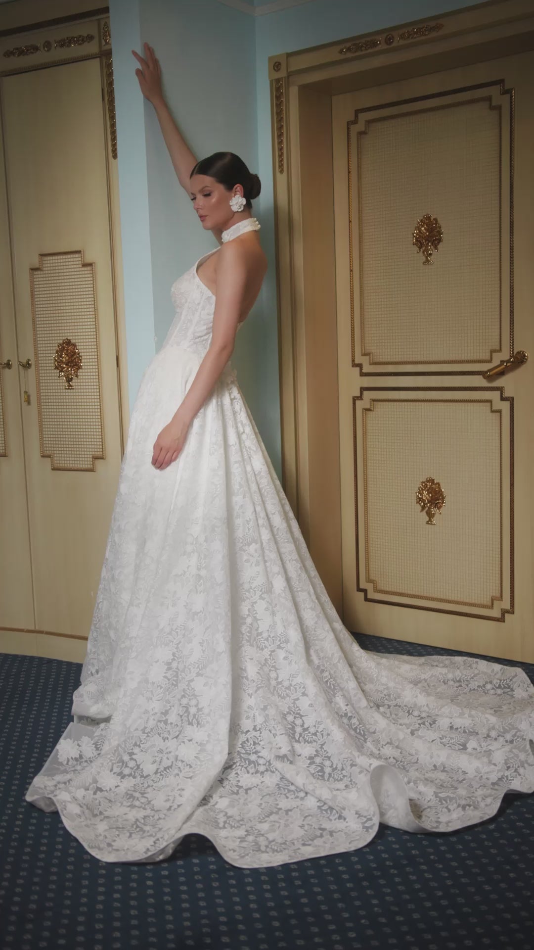 Lace A-line halter wedding dress with long removable sleeves adorned with 3D flowers, drop-down waist waspie corset, open lace-up back, and flowing chapel train for romantic bridal look