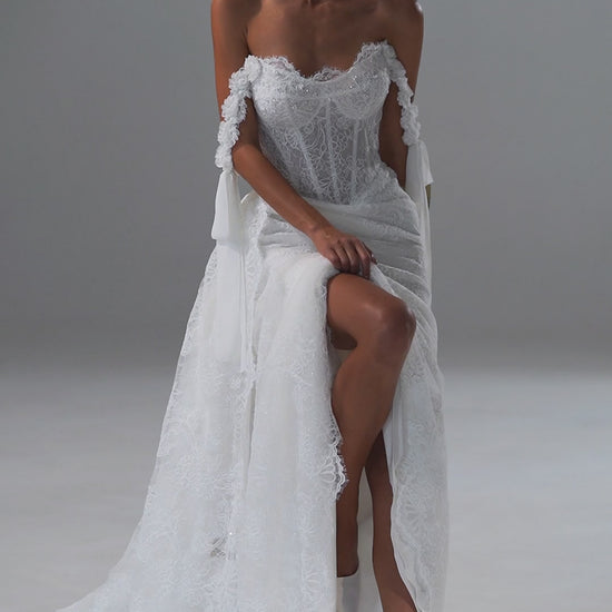 Lace wedding dress with off-shoulder corset, ribbon bows and scalloped train – video