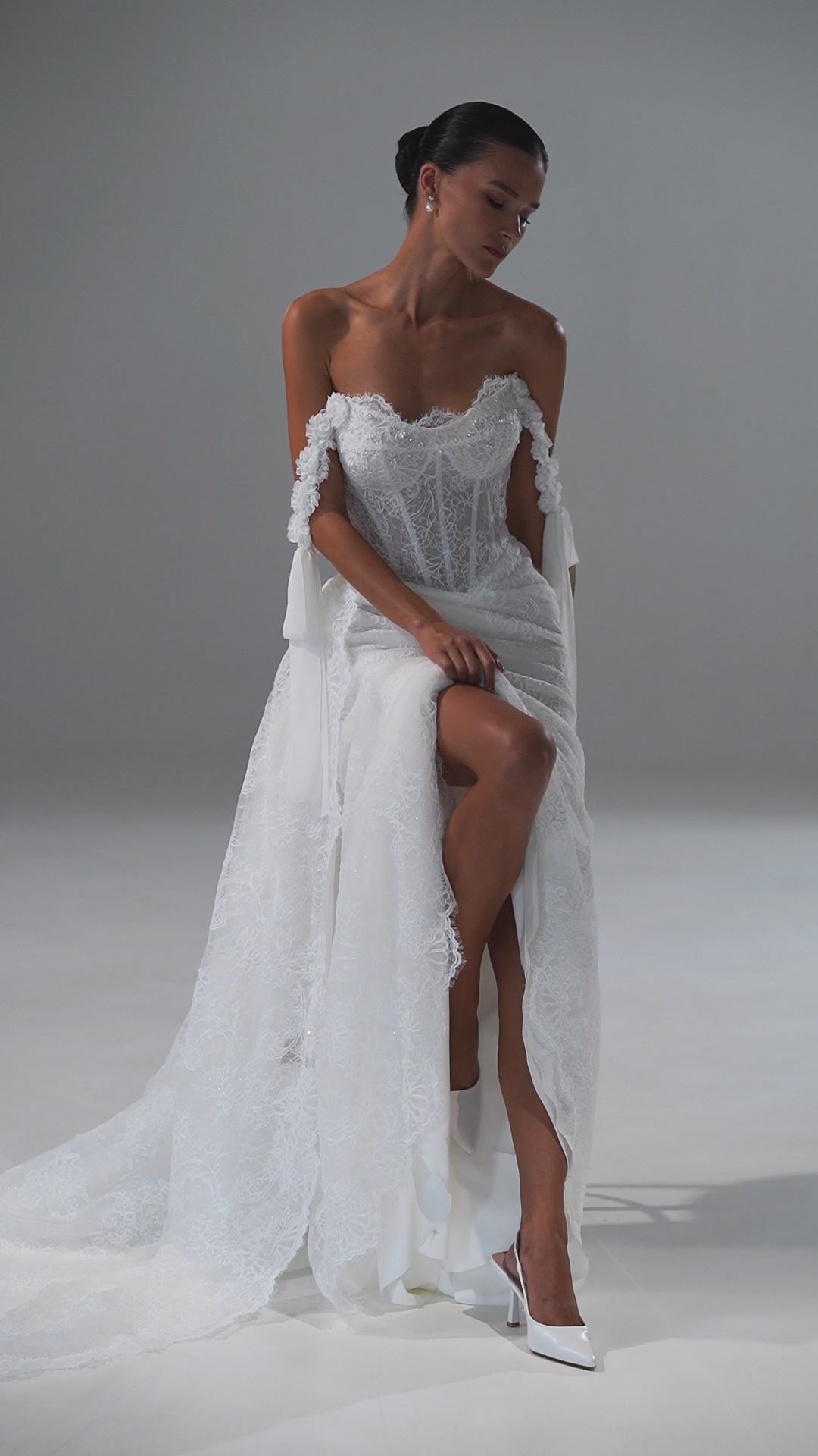 Lace wedding dress with off-shoulder corset, ribbon bows and scalloped train – video
