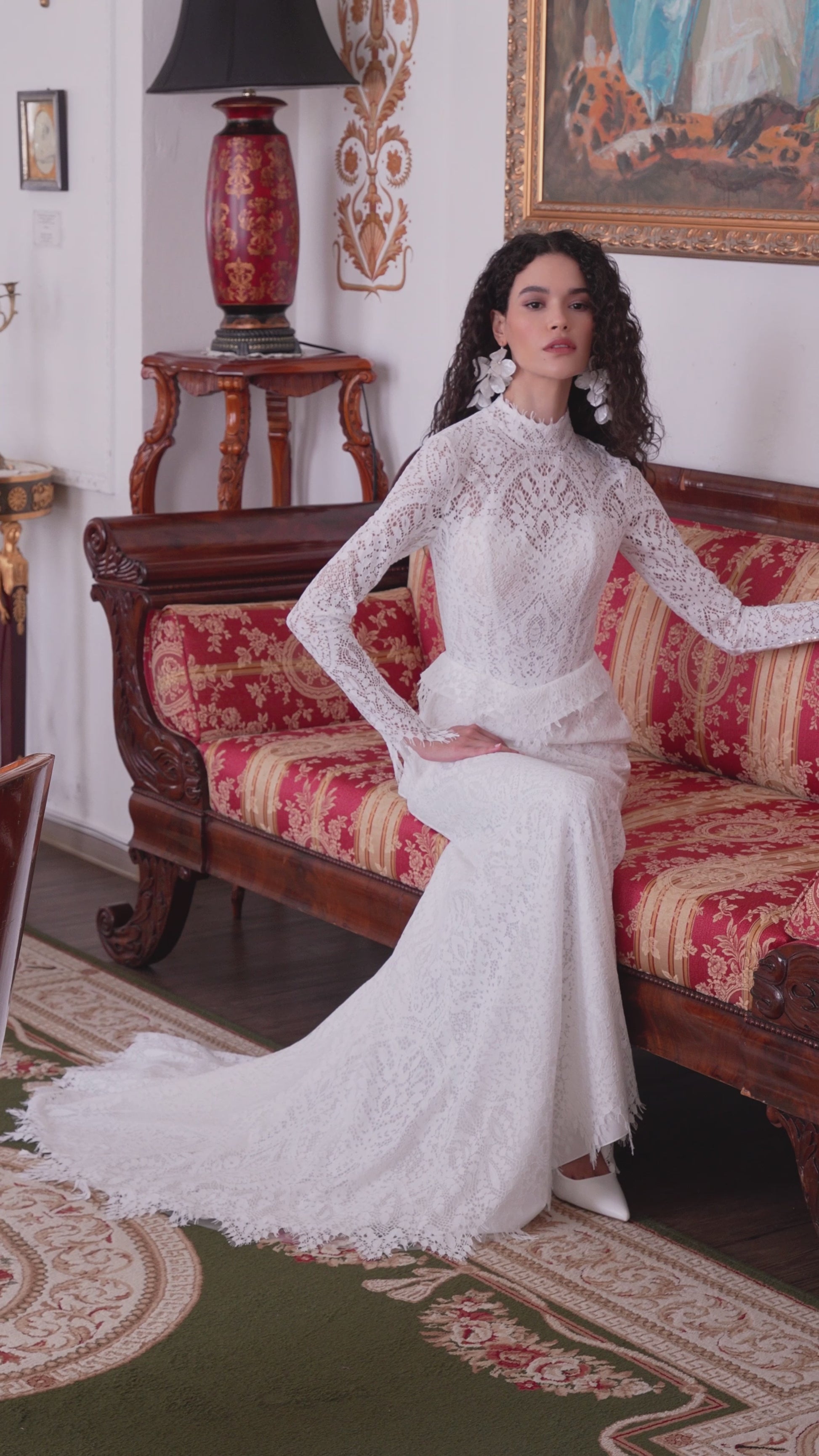 Long-sleeve high-neck lace mermaid wedding gown with open back and scalloped train.