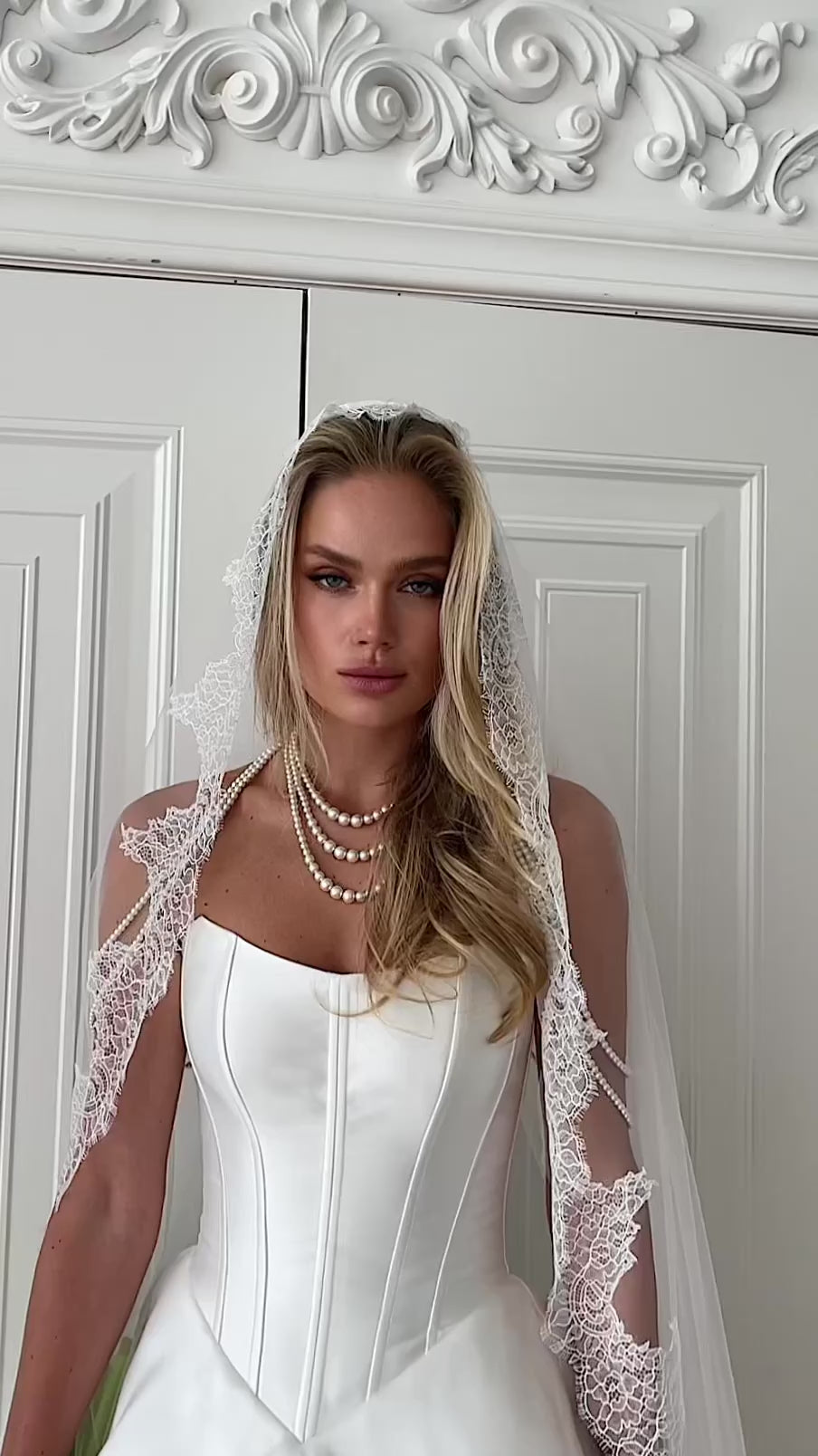 Video: close-up of a strapless corset with a lace-trimmed veil and pearl necklace