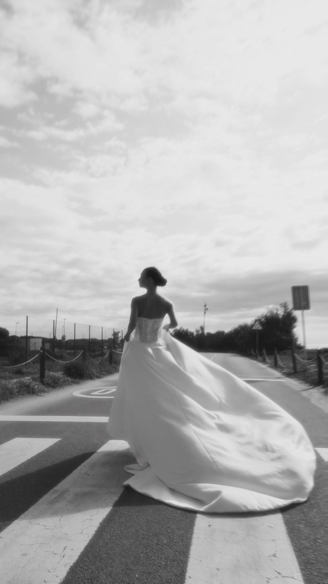 Bride in classic A-line atlas wedding gown with lace detail, V-cut neckline, drop waist, straight zip-closure back, and chapel train.