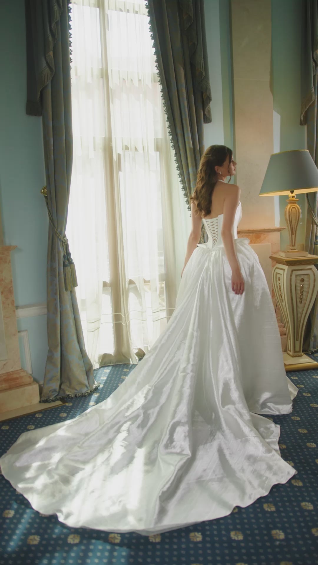 Bride wearing strapless taffeta corset wedding dress with pointed neckline, peplum waist detail, and full voluminous skirt.