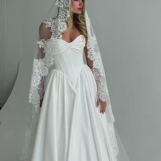 Video: bride in a satin A-line wedding dress with a long lace-trimmed veil